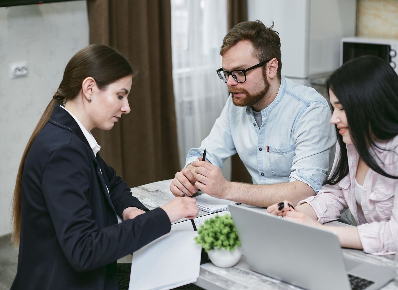 Home A couple discusses financial documents with their advisor, highlighting investment strategies.